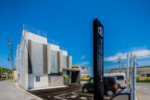 a street sign in a parking lot next to a building at BOND COMFORT HOTEL MIYAJIMAGUCHI - Vacation STAY 79234v in Hatsukaichi +6 photos