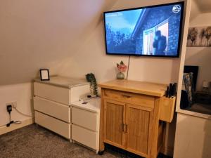 a living room with a flat screen tv on a wall at Loft Flat, near Hampton Court Palace, Free Parking in West Molesey
