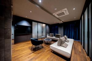 a living room with a couch and a tv at BOND COMFORT HOTEL MIYAJIMAGUCHI - Vacation STAY 80803v in Hatsukaichi