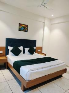 a bedroom with a large bed with black and white pillows at Hotel Royal Park Rooms in Vapi