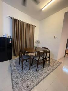 ein Esszimmer mit einem Tisch und Stühlen auf einem Teppich in der Unterkunft Orked Homestay 2 Parit Buntar in Parit Buntar