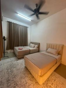2 Betten in einem Zimmer mit Deckenventilator in der Unterkunft Orked Homestay 2 Parit Buntar in Parit Buntar + 2 Fotos