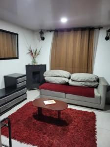 a living room with a bed and a coffee table at Apartastudio con baño privado y chimenea in Chía