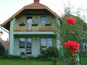 Casa con ventanas y balcón con rosas rojas. en Apartman Nóra II., en Bük