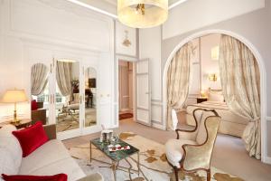 a living room with a couch and a bed and a table at Hôtel Regina Louvre in Paris