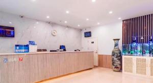 a lobby with a counter and a large vase at 7 Days Premium·Tianjin Gulou Metro Station Joy City in Tianjin