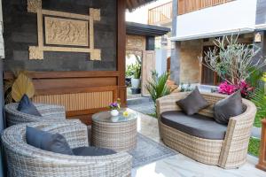 eine Terrasse mit zwei Korbstühlen und einem Tisch in der Unterkunft Hideaway Boutique - Uluwatu by Kanaan Hospitality in Uluwatu