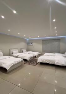 a row of beds in a room with a wall at شقق نرمادا المفروشة فرع قباء in Al Madinah