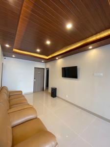 a living room with couches and a flat screen tv at The Bali Hotel in Sumedang Utara