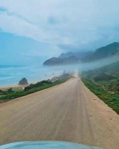 an empty road in the middle of a field at محمية حوف 