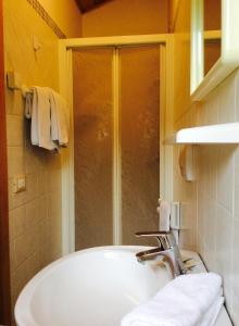 a bathroom with a tub and a shower with towels at B&B Sòl Fiorì in Agordo
