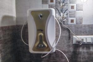 a soap dispenser on a wall in a bathroom at Gokarna Glimpse Getaway in Gokarna