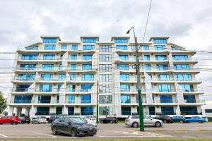 a large building with blue windows in a parking lot at Apar Ex Mamaia in Mamaia