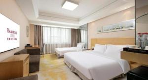 a hotel room with a large white bed and a tv at Ramada Plaza Shenyang Citycenter in Shenyang +110 photos
