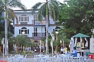a hotel with tables and chairs in front of a building at Subic Park Hotel in Olongapo