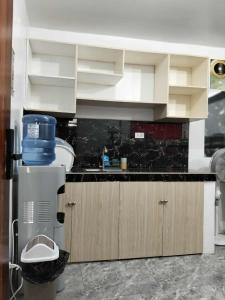 eine Küche mit weißen Schränken und einer schwarzen Arbeitsplatte in der Unterkunft W Tramo Residences in Manila + 7 Fotos