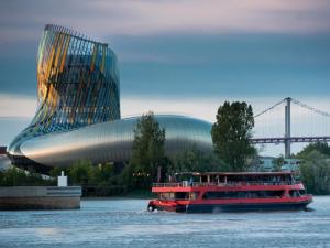 un bateau sur l'eau devant un bâtiment dans l'établissement Bellevue, à Carbon-Blanc