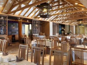 a dining room with white tables and chairs at Hotel Tentrem Yogyakarta in Yogyakarta