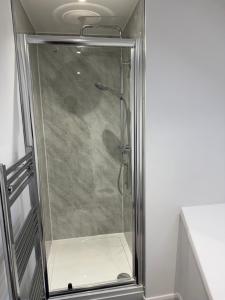 a shower with a glass door in a bathroom at Modern room in west hallam in Derby