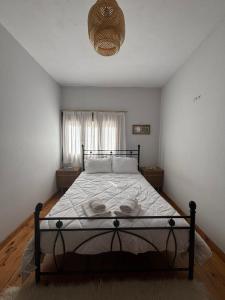 a bedroom with a bed in a room with a window at Η Μεγάλη Χαρούμενη Αρκούδα in Pávliani