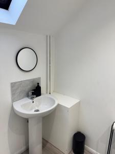 a white bathroom with a sink and a mirror at Modern room in west hallam in Derby