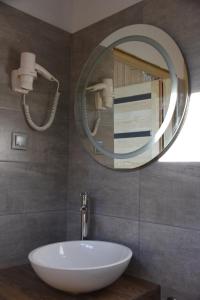 uma casa de banho com um lavatório branco e um espelho. em Ośrodek Delfin em Ślesin