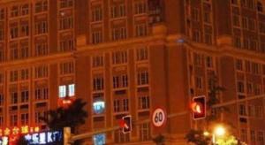 a traffic light and a large building at night at Chengdu Huadu Times Hotel in Chengdu