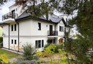 a white house with a black roof at OstseeVilla Seebad Ahlbeck Ferienwohnungen in Ahlbeck
