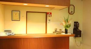an office counter with a phone and flowers on it at Yumekiko in Nasushiobara