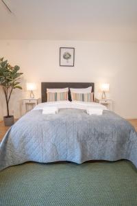 ein Schlafzimmer mit einem großen Bett mit zwei Lampen in der Unterkunft Linné Studio, Green Comfort Steps Away From Haga in Göteborg