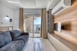 Una sala de estar con un sofá y un televisor. en Offshore Suites Apartment in St Julians Centre, en San Julián