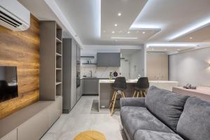Una sala de estar con un sofá y una cocina. en Offshore Suites Apartment in St Julians Centre, en San Julián