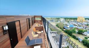 a balcony with chairs and tables on a building at Shirako New Seaside Hotel in Shirako