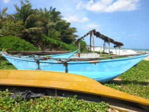 two boats sitting on the grass near the beach at Muthumala Villa in Tangalle
