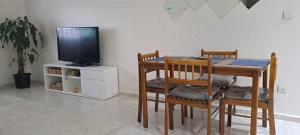 a dining room with a table with chairs and a tv at iris appart vue dégagée, bon emplacement in Sale