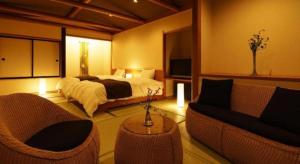 新発田市にあるHotel Masyuuのベッドルーム1室(ベッド1台、椅子2脚、ソファ付)