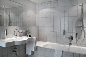 
a white sink sitting under a mirror in a bathroom at Hotel Restaurant Witte in Ahlen
