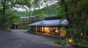 a house with a lot of windows in a forest at Myoken Ishiharaso in Kirishima