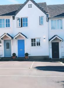 una casa bianca con porte blu su una strada di 2 Bedroom House, Park on Doorstep, Families and Contractors Friendly, Near Parkway Station a Bristol