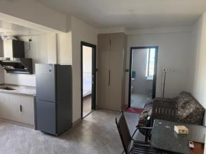 にあるRuifangju Homestay, Seaview Garden Communityのキッチン(冷蔵庫、テーブル、ソファ付)