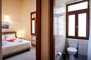 une salle de bain avec un lit et des toilettes dans une chambre dans l'établissement Odyssey Studios, à La Canée 64 autres photos