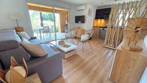 a living room with a couch and a table at Les Studios de Fiori - Studios et Appartement T2 - Cala Rossa - proche Porto Vecchio in Lecci