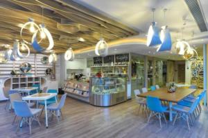 Un restaurante con sillas azules, una mesa y un mostrador. en SelfCheckIn TownHome in Charoen Nakhorn 60 near BTS Iconsiam Asiatique and Chaophraya River Maximum 4 Guests, en Bangkok