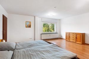 a white bedroom with a bed and a window at Fewo Schneider Bad Wildungen in Bad Wildungen