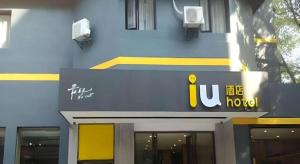 a building with a sign on the front of it at IU Hotel Guiyang North Station Shibei Road in Guiyang