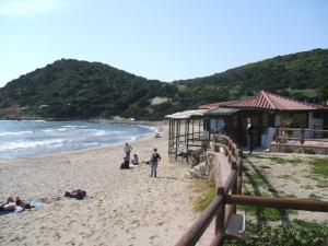 un grupo de personas en una playa cerca del océano en Su Cantaru Guesthouse, en Villanova Monteleone