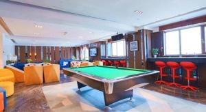 a room with a pool table and red chairs at Zmax Hotel·Xining Wanda Plaza in Xining