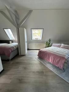 a bedroom with two beds and two windows at Oppiner Straße 14 Trotha4 in Halle an der Saale