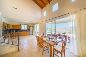 a dining room with a table and chairs and a kitchen at Villa Gina by Villa Plus in Klimatiá