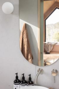 - un miroir au-dessus d'un lavabo dans la salle de bains dans l'établissement SkyDreamer - Tiny Home at Jamberoo Mountain Farm, à Tongarra